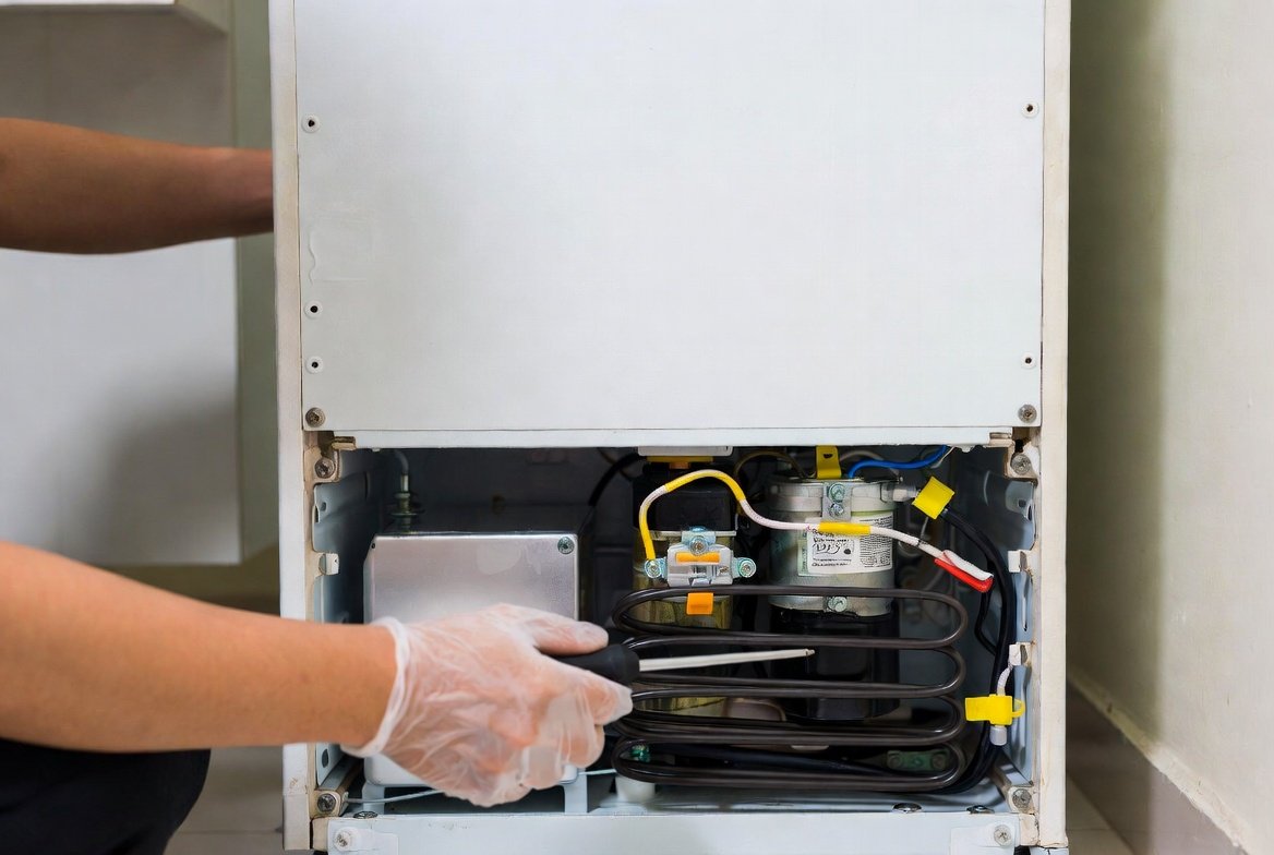 Refrigerator compressor and condenser coils during repair